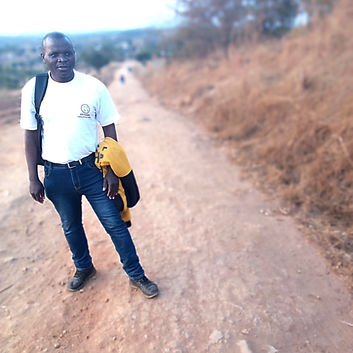 The Executive Director of the KEYS Organization on a gravel road walking.